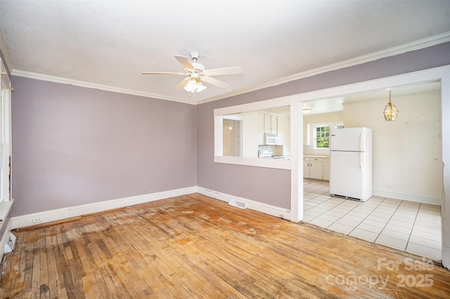 813 S Ridge Ave, Kannapolis, NC 28083 - spare room with a ceiling fan, baseboards, crown molding, and light wood-style floors