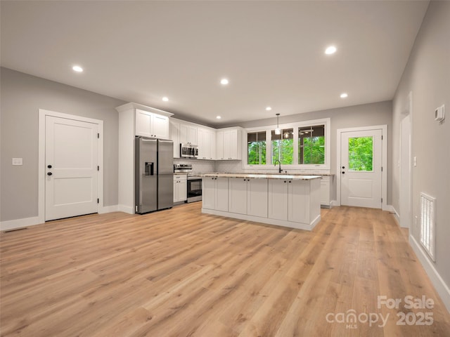 109 Ashley Ct, Mill Spring, NC 28756 - kitchen with appliances with stainless steel finishes, white cabinetry, a sink, light countertops, and recessed lighting