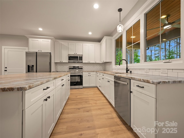 109 Ashley Ct, Mill Spring, NC 28756 - kitchen featuring appliances with stainless steel finishes, a sink, decorative backsplash, recessed lighting, and white cabinetry