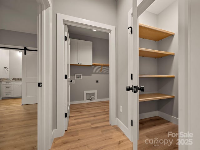 109 Ashley Ct, Mill Spring, NC 28756 - laundry area with cabinet space, electric dryer hookup, washer hookup, a barn door, and light wood finished floors