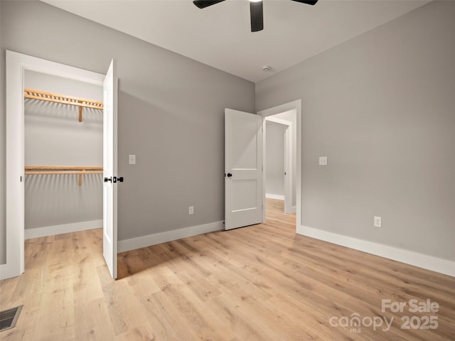 109 Ashley Ct, Mill Spring, NC 28756 - unfurnished bedroom with light wood-type flooring, baseboards, a closet, a ceiling fan, and a spacious closet
