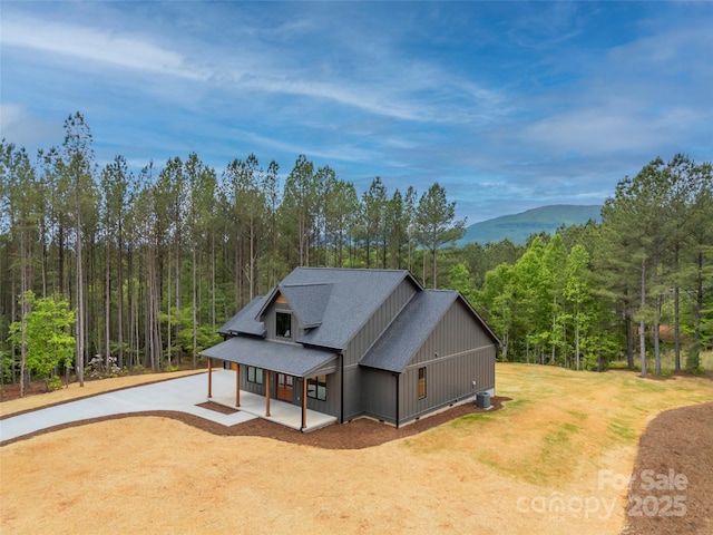109 Ashley Ct, Mill Spring, NC 28756 - view of home's exterior with concrete driveway, a wooded view, a shingled roof, and board and batten siding