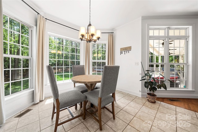 dining room with light tile patterned flooring, a chandelier, crown molding, baseboards, and healthy amount of natural light