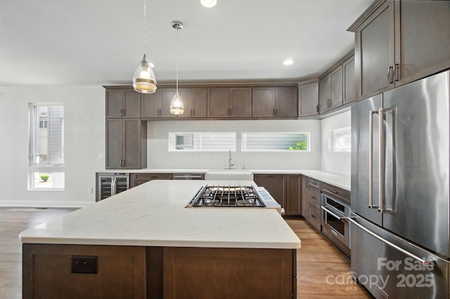 945 Westbrook Dr Unit A, Charlotte, NC 28202 - kitchen with stainless steel appliances, wine cooler, a center island, light wood-style flooring, and crown molding
