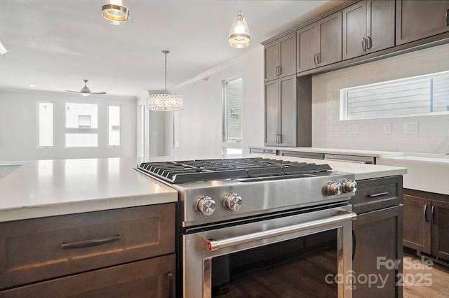 945 Westbrook Dr Unit A, Charlotte, NC 28202 - kitchen featuring gas range, light countertops, tasteful backsplash, crown molding, and pendant lighting