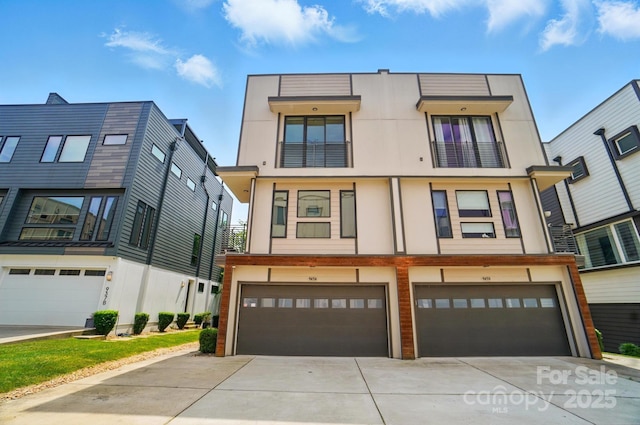 945 Westbrook Dr Unit A, Charlotte, NC 28202 - view of property featuring a garage, concrete driveway, and stucco siding