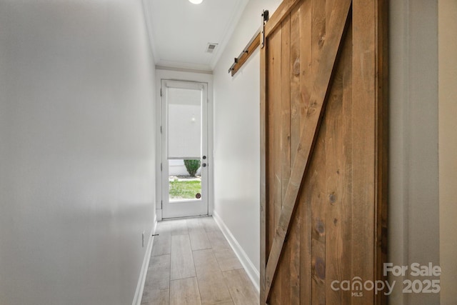 945 Westbrook Dr Unit A, Charlotte, NC 28202 - hallway with a barn door, ornamental molding, and light wood-type flooring