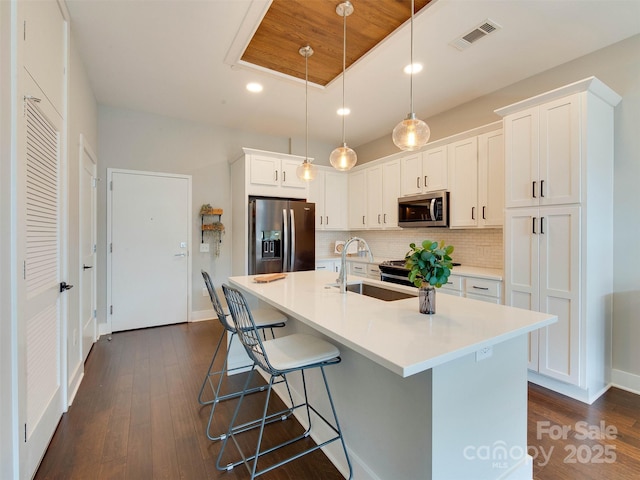 2401 Euclid Ave Unit 207, Charlotte, NC 28203 - kitchen with stainless steel appliances, dark wood-style floors, tasteful backsplash, white cabinetry, and recessed lighting