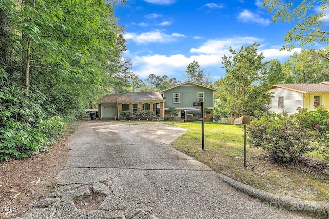 split level home featuring a front yard, a garage, and driveway