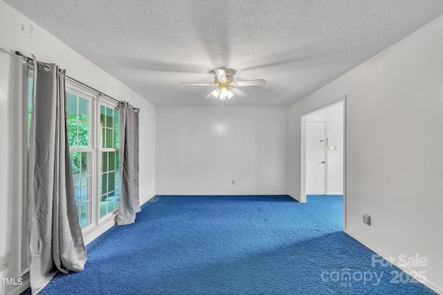 empty room with a textured ceiling, baseboards, a ceiling fan, and carpet floors