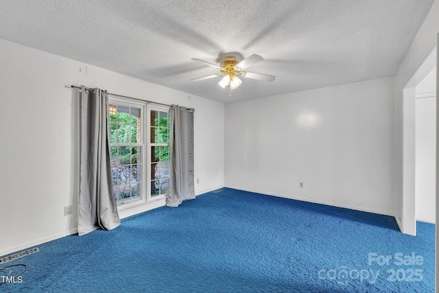 carpeted empty room with a ceiling fan and a textured ceiling