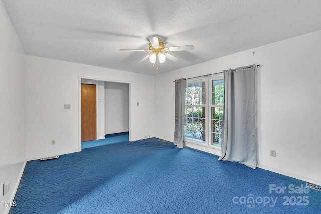 spare room with carpet flooring, a textured ceiling, baseboards, and ceiling fan