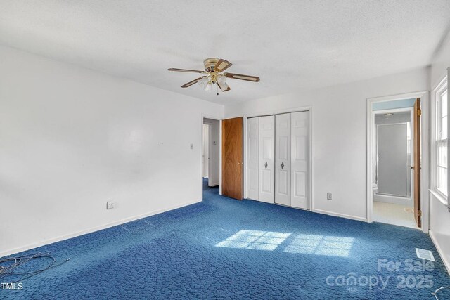 unfurnished bedroom with a textured ceiling, carpet, visible vents, connected bathroom, and baseboards