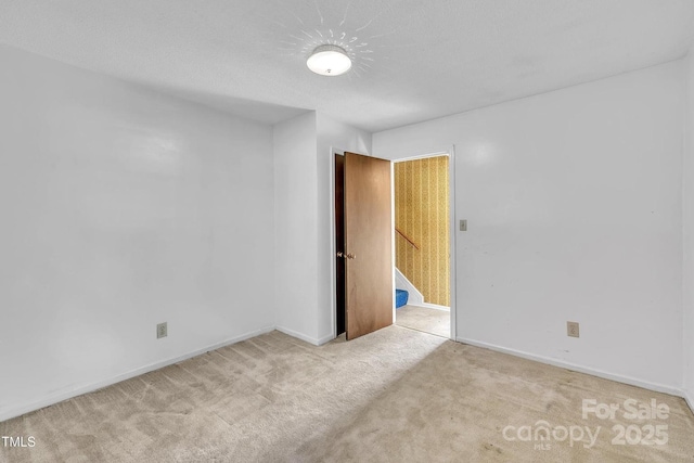 carpeted empty room with baseboards