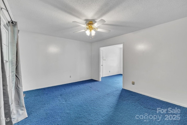 carpeted spare room with a textured ceiling, baseboards, and a ceiling fan