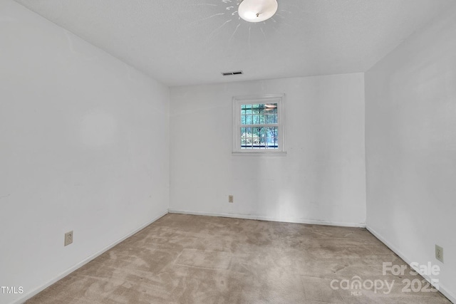 carpeted empty room with baseboards and visible vents