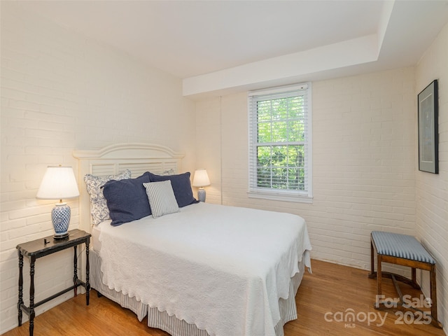 203 Lake Dr, Hendersonville, NC 28739 - bedroom with brick wall and wood finished floors