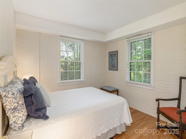 203 Lake Dr, Hendersonville, NC 28739 - bedroom featuring brick wall, multiple windows, and wood finished floors
