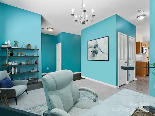home office with a chandelier, wood finished floors, and baseboards
