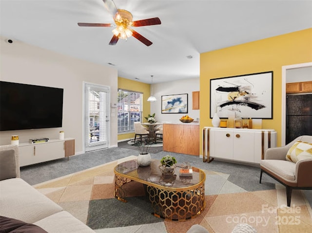 living room featuring light colored carpet and a ceiling fan
