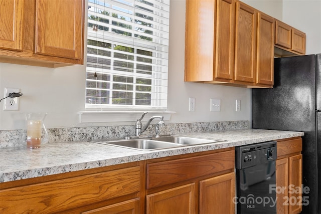 kitchen with a sink, black appliances, plenty of natural light, and light countertops