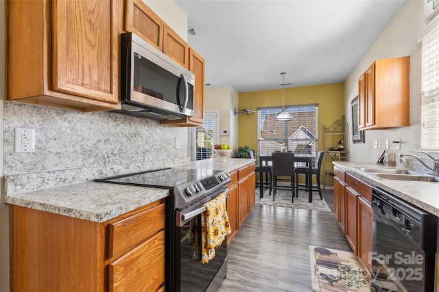 kitchen featuring stainless steel appliances, a sink, light countertops, and decorative backsplash