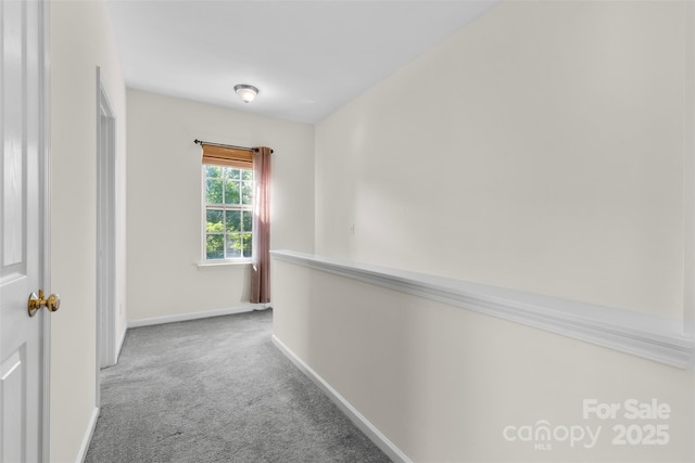 corridor with carpet flooring and baseboards
