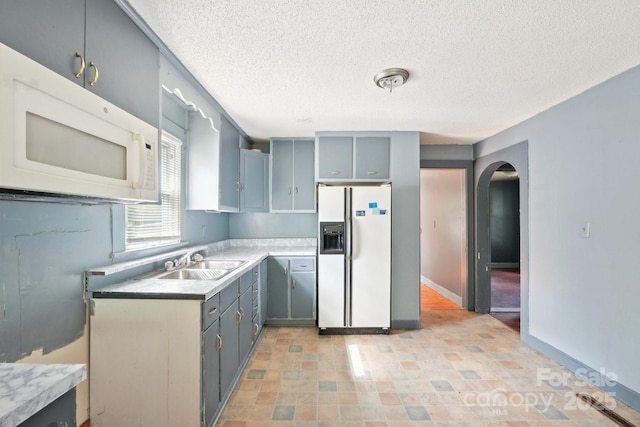 409 Rosemont Ave, Kannapolis, NC 28081 - kitchen with a sink, white appliances, a textured ceiling, arched walkways, and light countertops