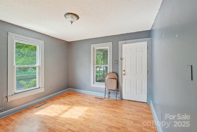 409 Rosemont Ave, Kannapolis, NC 28081 - unfurnished room featuring plenty of natural light, visible vents, wood finished floors, and a textured ceiling