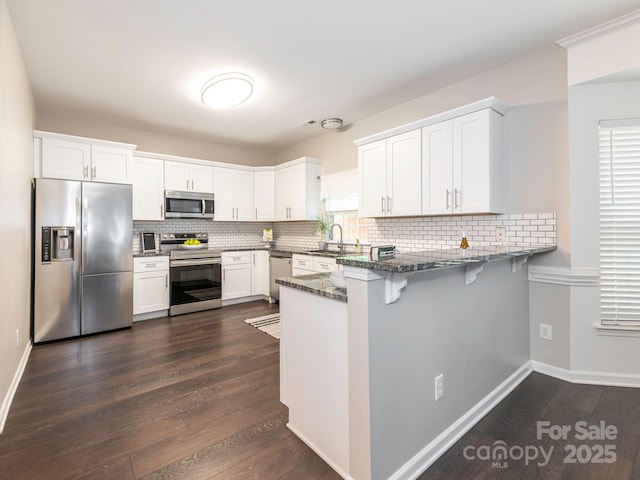 3626 Cole Mill Rd, Charlotte, NC 28270 - kitchen with stainless steel appliances, a peninsula, a sink, dark stone counters, and white cabinetry