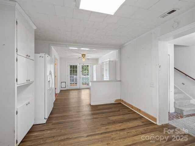 kitchen with white refrigerator with ice dispenser, dark wood-type flooring, and white cabinets