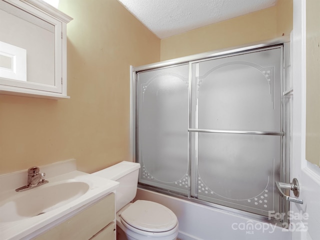 bathroom featuring shower / bath combination with glass door, a textured ceiling, vanity, and toilet
