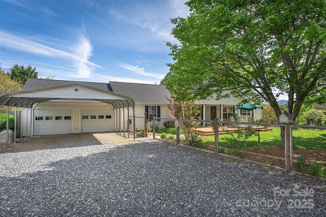 ranch-style house featuring a shingled roof, fence, and a detached garage