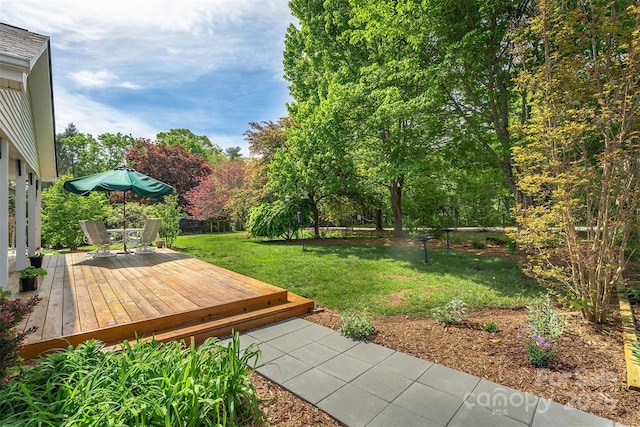 view of yard with a wooden deck and outdoor dining area