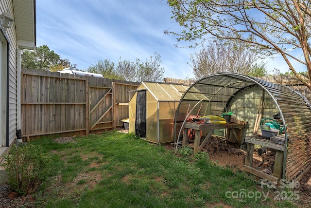 view of yard featuring a fenced backyard, an outbuilding, and an exterior structure