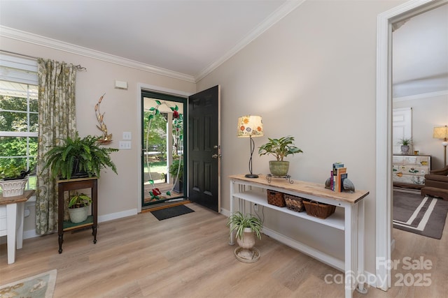 foyer entrance featuring baseboards, light wood finished floors, and crown molding