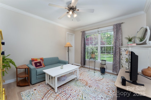 living room with crown molding, light wood-type flooring, baseboards, and ceiling fan