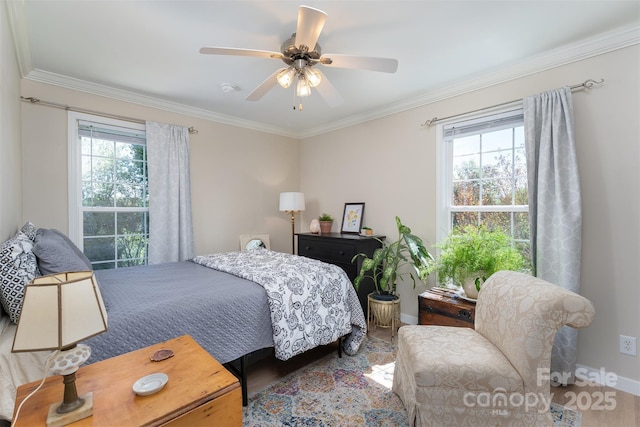 bedroom featuring multiple windows, wood finished floors, baseboards, and crown molding