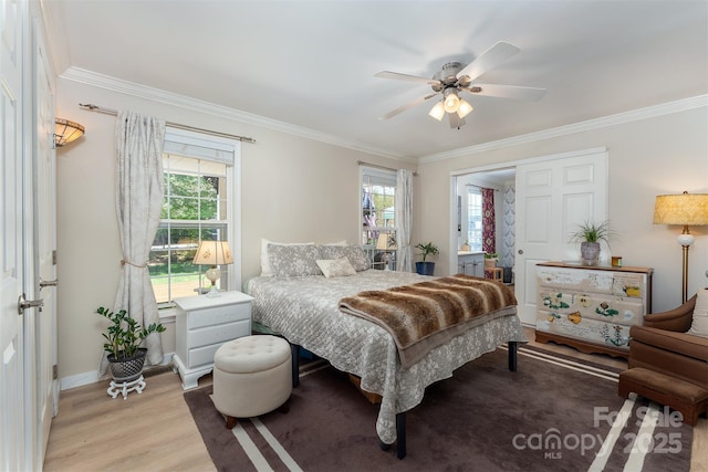 bedroom with baseboards, multiple windows, ornamental molding, and light wood finished floors