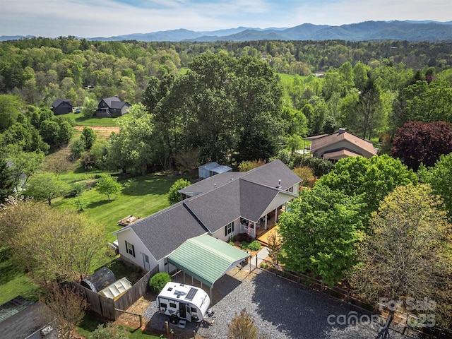 birds eye view of property featuring a mountain view and a wooded view