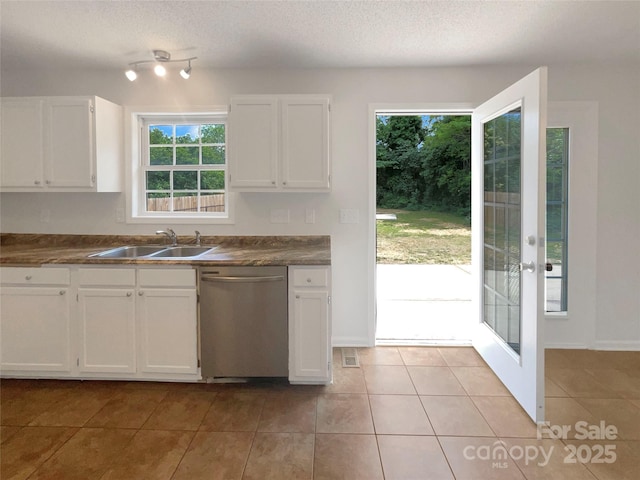 kitchen featuring a sink, stainless steel dishwasher, white cabinetry, and dark countertops