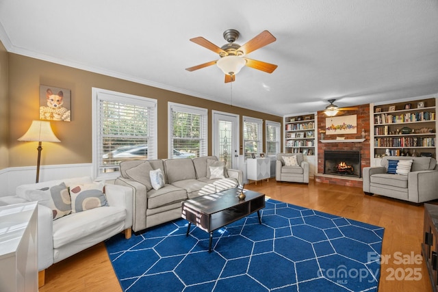 25 Alpine Way, Clyde, NC 28721 - living room featuring ceiling fan, healthy amount of natural light, crown molding, wood finished floors, and a fireplace