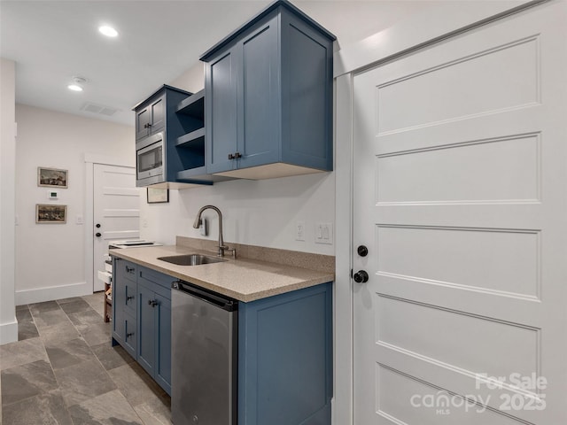 kitchen featuring refrigerator, a sink, open shelves, visible vents, and blue cabinetry