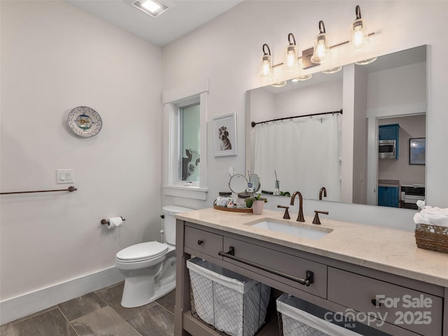 bathroom with toilet, visible vents, baseboards, and vanity