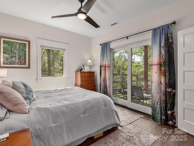 bedroom with multiple windows, access to outside, visible vents, and wood finished floors