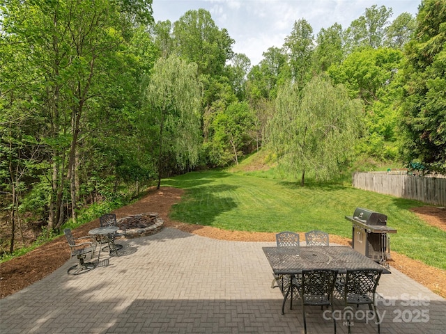 view of patio / terrace with an outdoor fire pit, fence, a grill, and outdoor dining space