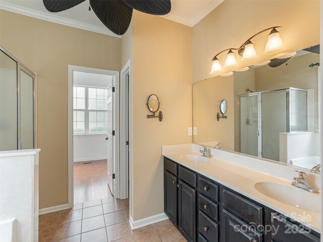 full bath with a sink, ornamental molding, a stall shower, and tile patterned floors