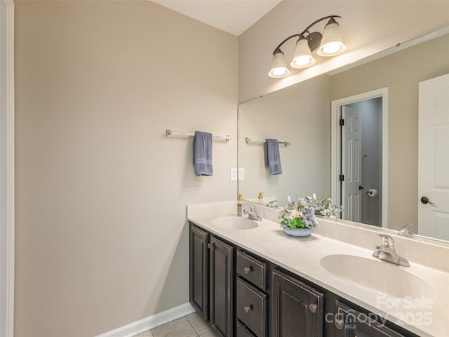 full bathroom with baseboards, tile patterned flooring, double vanity, and a sink