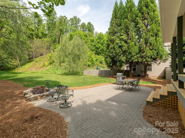 view of patio / terrace with fence, a fire pit, and outdoor dining space