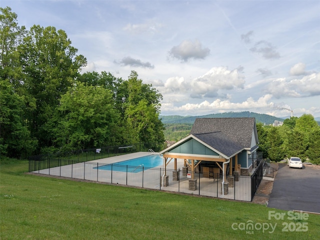 view of swimming pool with a lawn, a fenced in pool, and fence